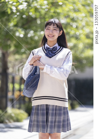 スクールバッグを肩にかけて歩く笑顔の女子高校生　 133059707