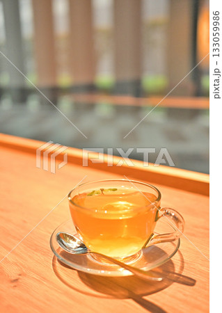 ガラスカップのハーブティーと窓辺の癒しのティータイム 133059986