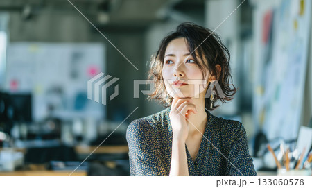 綺麗なオフィスでタスクについて思い巡らせる女性社員　落ち着いた静寂の中で考える仕事シーン 133060578