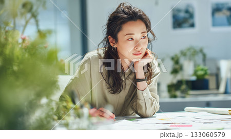 モダンな職場で資料を前に思案するビジネスウーマン　集中した表情が印象的なデスクワーク風景 133060579