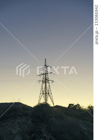 Power Line Tower at Sunset. Energy and Industrial Silhouette 133060842