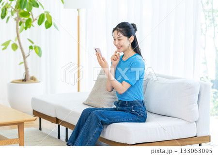 部屋でスマホを操作する女性 部屋でスマホを操作する女性 133063095