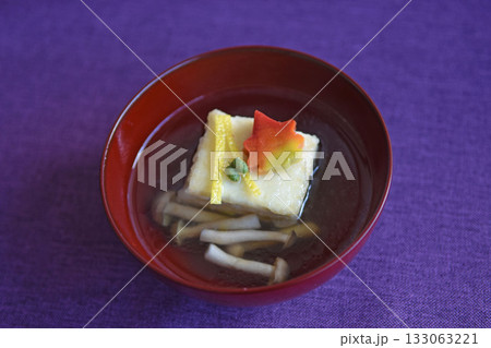朱塗りのお椀にはった出汁に揚げ出し豆腐ともみじ麩はあたたかい上品な秋の会席料理 133063221