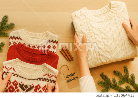 Holiday donation with folded sweaters and pine branches, background 133064413