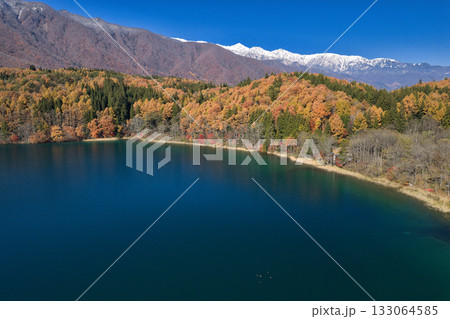 紅葉に包まれた青木湖と冠雪した白馬三山　長野県大町市（ドローンによる空撮） 133064585