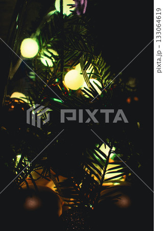 Christmas tree lights, vertical. Christmas tree with bulb garland, close up. Evergreen tree with Christmas decoration. New Year mood. Festive illumination and spruce tree with needles. Merry Christmas Christmas tree lights, vertical. Christmas tree with bulb garland, close up. Evergreen tree with Christmas decoration. New Year mood. Festive illumination and spruce tree with needles. Merry Christmas 133064619