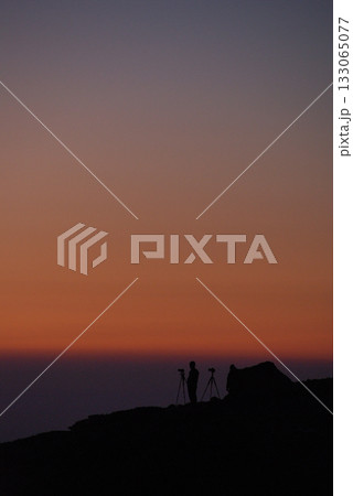 早朝の山頂で御来光の瞬間を待つカメラマンたちのシルエット(冬の朝，超望遠ズーム撮影) 133065077