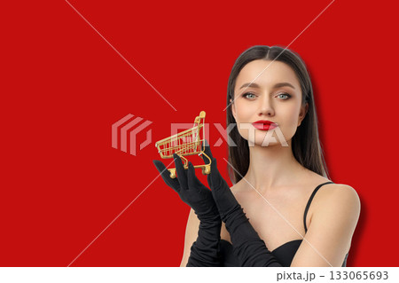 Woman with dark hair and red lips poses with gold cart 133065693