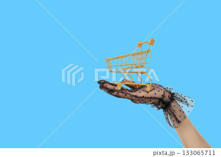 Black glove with a gold cart on a blue background Black glove with a gold cart on a blue background 133065711