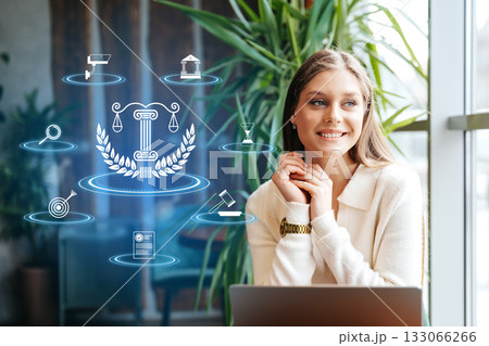 Young woman smiles near legal icons and plants indoors Young woman smiles near legal icons and plants indoors 133066266