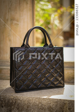 Elegant Brown Quilted Handbag On Outdoor Scenery, Fashion Accessory For Women 133066527