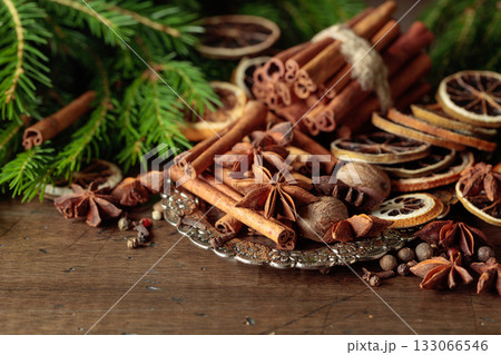 Various Christmas spices with dried citrus slices on silver tray. 133066546