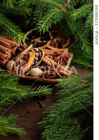 Spices and branches of Christmas tree on an old wooden table. Spices and branches of Christmas tree on an old wooden table. 133066548