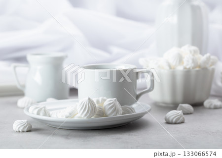 Vanilla meringue and coffee cup on a white marble table. 133066574
