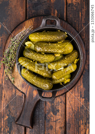 Artisan Pickled Gherkins, pickled cucumbers, beautifully arranged and ready to elevate your culinary creations with their bold taste. wooden background. top view Artisan Pickled Gherkins, pickled cucumbers, beautifully arranged and ready to elevate your culinary creations with their bold taste. wooden background. top view 133066745