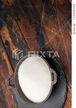 Bright and clean granulated sugar, an essential ingredient for delicious treats and drinks. wooden background. top view Bright and clean granulated sugar, an essential ingredient for delicious treats and drinks. wooden background. top view 133066782