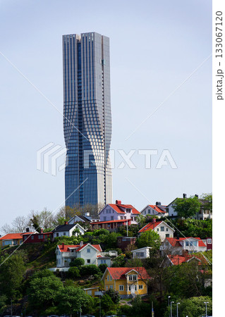 Colony of small wooden historic houses on the Slottsberget mountain with the tallest Scandinavian building Karlatornet skycraper in Lindholmen in background, Gothenburg, Sweden Colony of small wooden historic houses on the Slottsberget mountain with the tallest Scandinavian building Karlatornet skycraper in Lindholmen in background, Gothenburg, Sweden 133067120