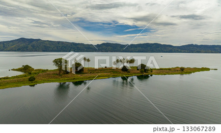 Aerial drone of beautiful Lake Toba and an island with palm trees. Samosir, Pulau Toba. Sumatra, Indonesia. Aerial drone of beautiful Lake Toba and an island with palm trees. Samosir, Pulau Toba. Sumatra, Indonesia. 133067289