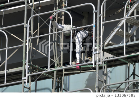 工事現場 新築マンション 仮設足場の解体作業風景 工事現場 新築マンション 仮設足場の解体作業風景 133067595