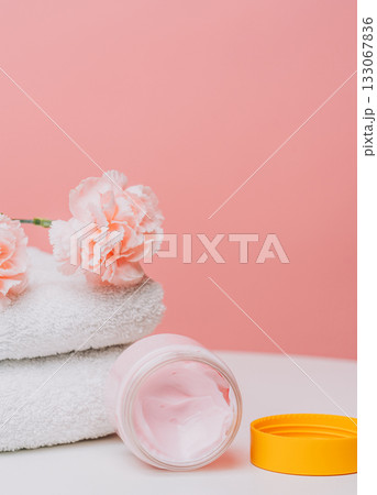 Skincare cream jar with carnations and towel 133067836