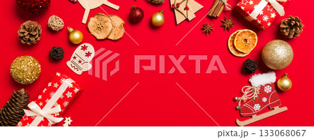 Top view of Christmas decorations on red background. New Year holiday concept with copy space Top view of Christmas decorations on red background. New Year holiday concept with copy space 133068067