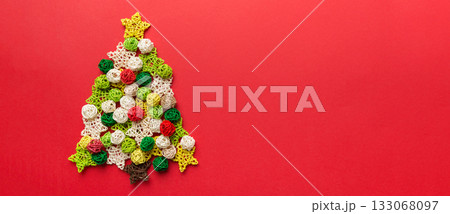 Christmas tree made from colored handmade ball decoration on colored background, view from above. New Year minimal concept with copy space 133068097