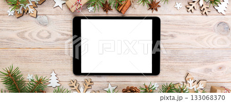Digital tablet mock up with rustic Christmas wood background decorations for app presentation. top view with copy space 133068370