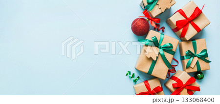 wrapped christmas or other holiday handmade present in paper with colored ribbon. Present box, decoration of gift on colourfull table, top view with copy space 133068400