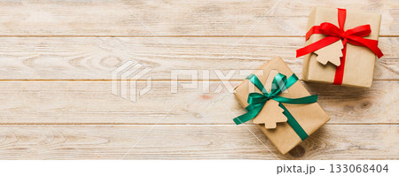 wrapped christmas or other holiday handmade present in paper with colored ribbon. Present box, decoration of gift on colourfull table, top view with copy space wrapped christmas or other holiday handmade present in paper with colored ribbon. Present box, decoration of gift on colourfull table, top view with copy space 133068404