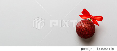 Christmas ball on colored background. decoration bauble with ribbon bow with copy space 133068416