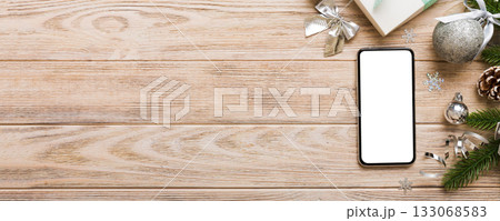 Digital phone mock up with rustic Christmas decorations for app presentation top view with empty space for you design. Christmas online shopping concept. Tablet with copy space on colored background 133068583