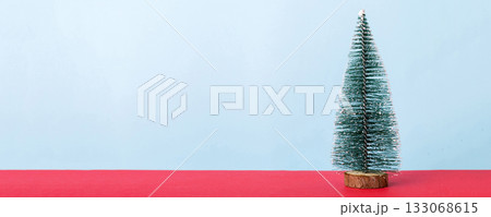 One small Christmas tree on colored background. new year decoration with copy space 133068615