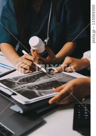 Group of doctors attending seminar in hospital lecture hall with senior physician giving medical presentation and professional training session on healthcare practices Group of doctors attending seminar in hospital lecture hall with senior physician giving medical presentation and professional training session on healthcare practices 133069300