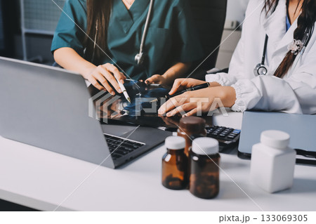 Group of doctors attending seminar in hospital lecture hall with senior physician giving medical presentation and professional training session on healthcare practices 133069305