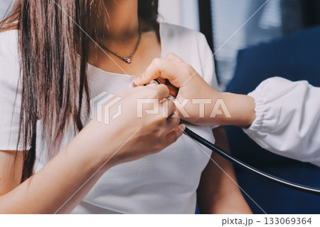 Doctor examining patient with stethoscope in hospital bed. Medical care and healthcare concept in a clinical setting. Doctor examining patient with stethoscope in hospital bed. Medical care and healthcare concept in a clinical setting. 133069364