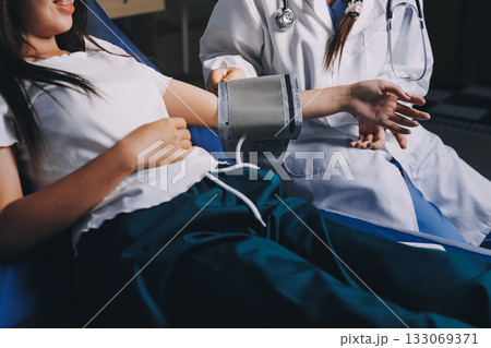 Nurse measuring blood pressure of elderly woman at table, closeup. Assisting senior generation Nurse measuring blood pressure of elderly woman at table, closeup. Assisting senior generation 133069371