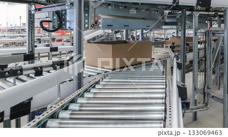 packing line in a logistics warehouse. conveyor belt in a modern production line packing line in a logistics warehouse. conveyor belt in a modern production line 133069463
