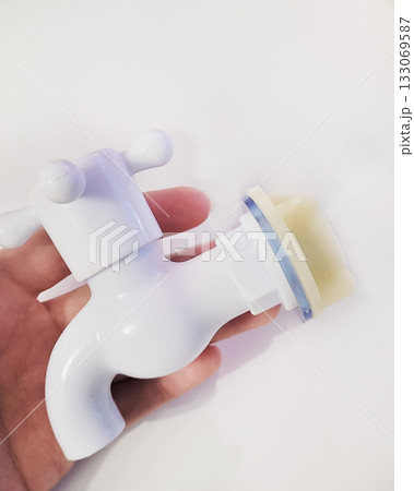 White Plastic Faucet Held in Human Hand White Plastic Faucet Held in Human Hand 133069587