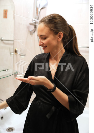 Woman Applying Skin Care in Bathroom Woman Applying Skin Care in Bathroom 133069934