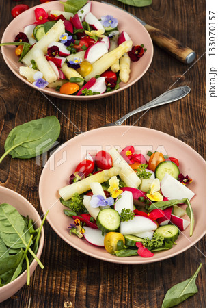 mixed greens salad with edible flowers. 133070157