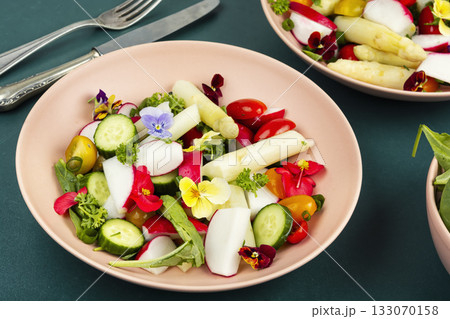mixed greens salad with edible flowers. 133070158