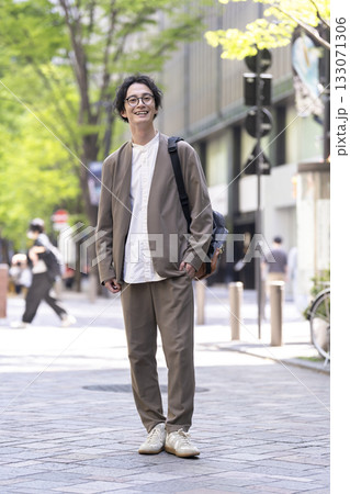 カメラ目線で笑顔の街角に立つ30代の男性 133071306