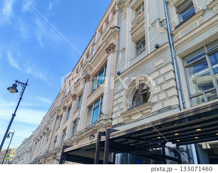 large multi-story building with a classic facade featuring arched windows and modern retail spaces on the ground floor. The blend of traditional architecture and urban commercial life reflects the 133071460