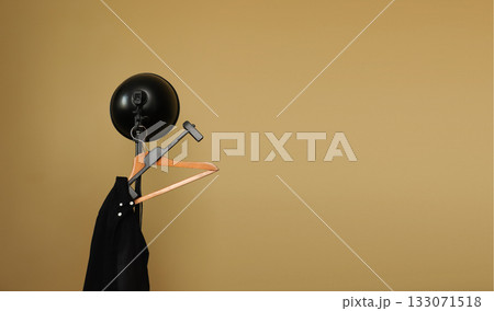 Black jacket on wooden hanger under studio light against beige background. fashion retail black clothing shirt jacket display Black jacket on wooden hanger under studio light against beige background. fashion retail black clothing shirt jacket display 133071518