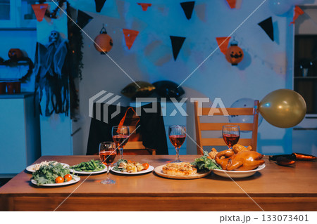 Joyful office Halloween party with coworkers in costumes, celebrating with drinks and laughter, fostering teamwork and festive spirit 133073401