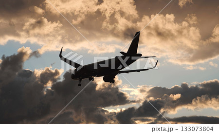 Airplane approaching airport runway for landing at beautiful sunset with dramatic clouds Airplane approaching airport runway for landing at beautiful sunset with dramatic clouds 133073804
