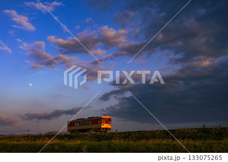 夕日を浴びて走るローカル線 133075265