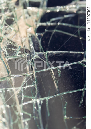 the cracked glass of a car after a road accident, the details of the windshield of a car cracked during an accident on the road, close up the cracked glass of a car after a road accident, the details of the windshield of a car cracked during an accident on the road, close up 133075634