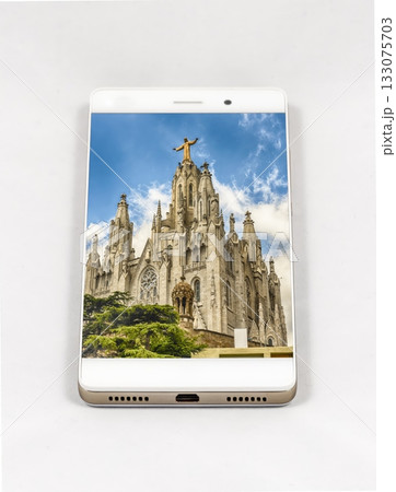 Smartphone displays Sagrat Cor church, Barcelona, with Christ statue against Smartphone displays Sagrat Cor church, Barcelona, with Christ statue against 133075703