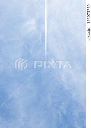 青空を覆う薄雲の中を突き抜ける飛行雲 133075750